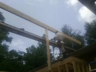 Carpenter setting a ridge beam over a new addition frame — Ice Dam Removal by Roofing Brothers in Ramah
